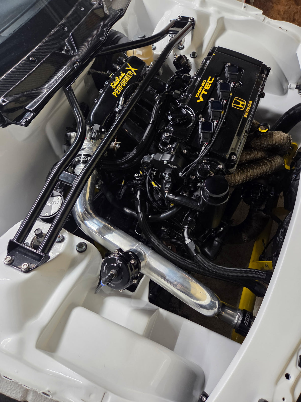 Angled view of a Honda engine bay with a VTI Motorsports Link ECU harness installation